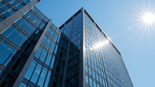 现代办公楼外观,玻璃幕墙设计,阳光照射下建筑显得庄重大气,体现企业实力